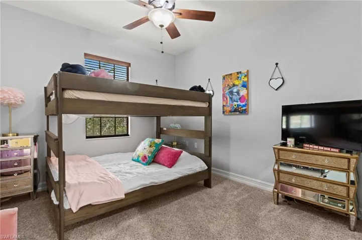 Carpeted bedroom featuring baseboards and a ceiling fan
