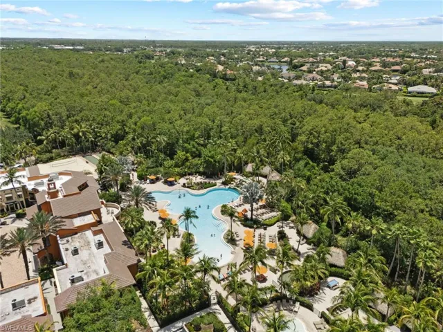 Aerial view of property and surrounding area featuring a pool and a forest