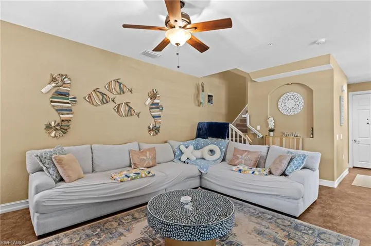 Living area with ceiling fan and baseboards