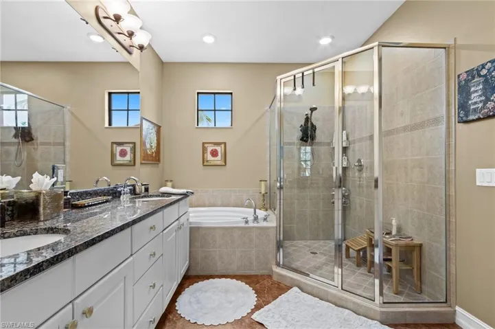 Full bath with a bath, a stall shower, double vanity, recessed lighting, and tile patterned flooring