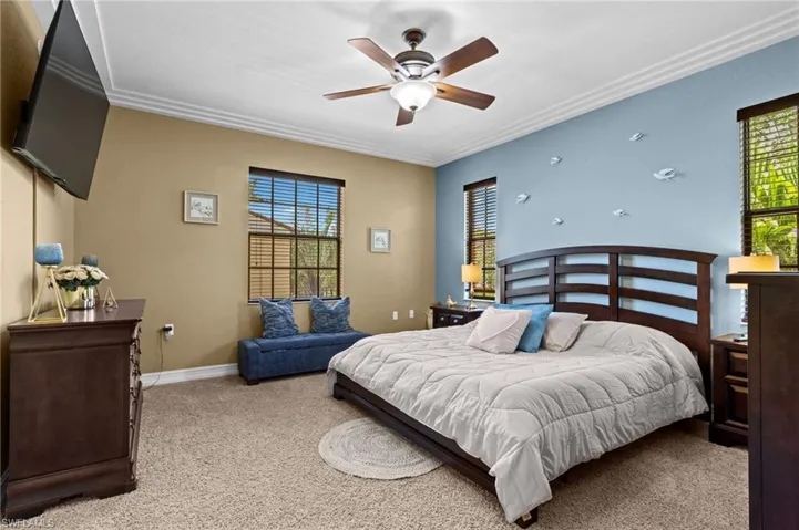 Bedroom featuring ornamental molding, carpet, baseboards, and ceiling fan
