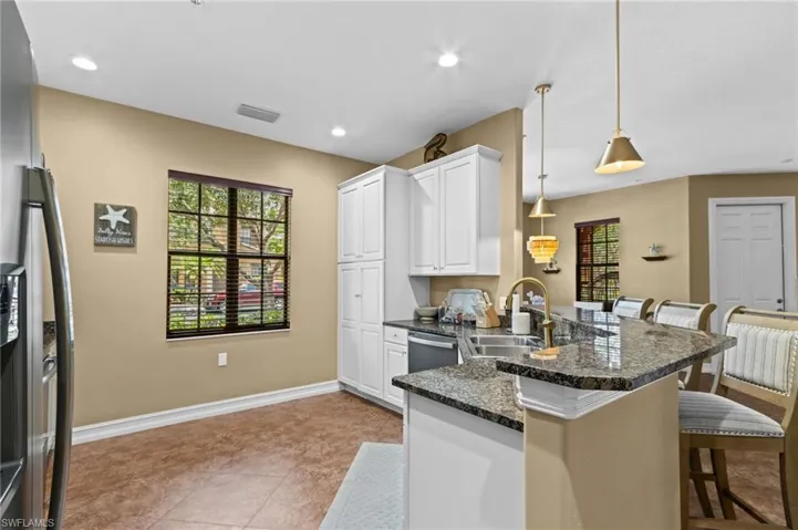 Kitchen with a sink, a peninsula, a kitchen breakfast bar, healthy amount of natural light, and recessed lighting