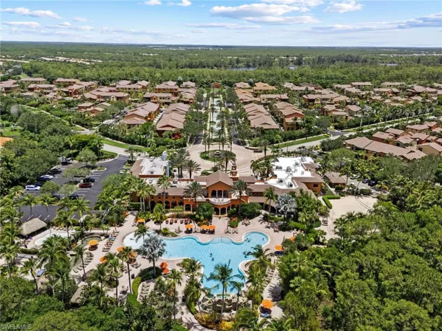 View of property location with a pool, nearby suburban area, and a heavily wooded area