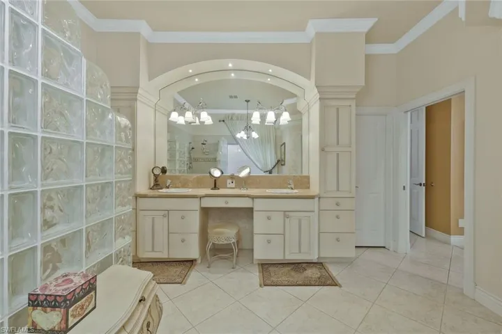 Large en-suite primary bathroom with dual vanities and a large mirror.