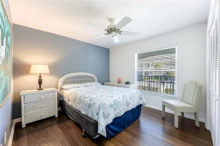 Bedroom with dark wood-style flooring, ceiling fan, and a closet