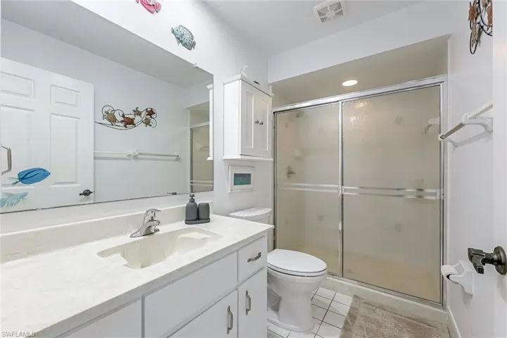 Bathroom with a shower stall, vanity, and light tile patterned floors