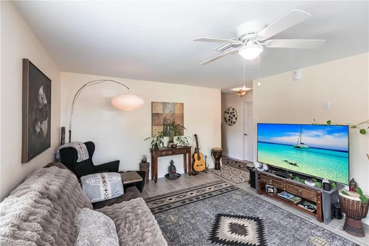 Living room featuring wood finished look tile  floors and ceiling fan
