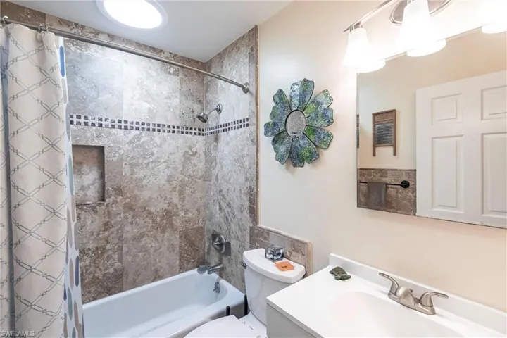 Full bathroom with shower / tub combo with curtain and vanity