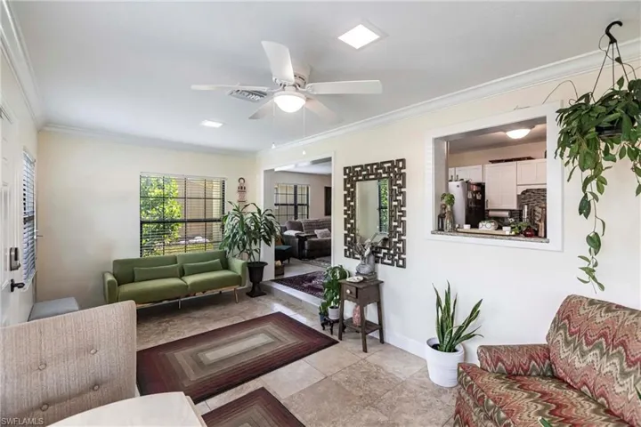 Your Living area featuring crown molding tile flooring & ceiling fan