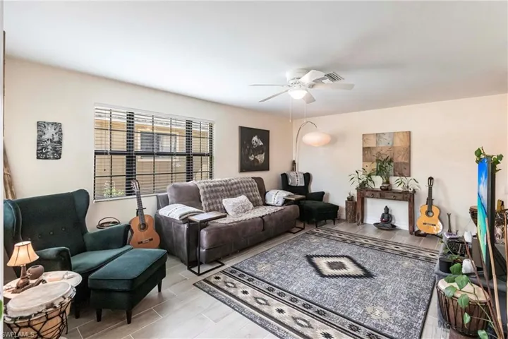 Living room with wood finish wood look tile floors and ceiling fan