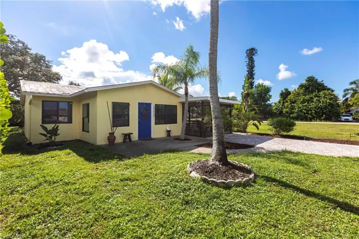 View of your front yard, patio, NEW decorative driveway, and metal roof