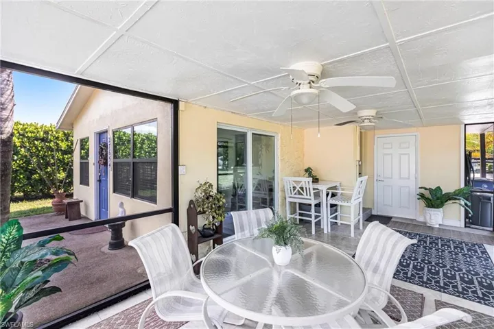 Sunroom / solarium with outdoor dining space and a ceiling fan