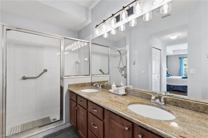 Bathroom with dual bowl vanity and a shower with door