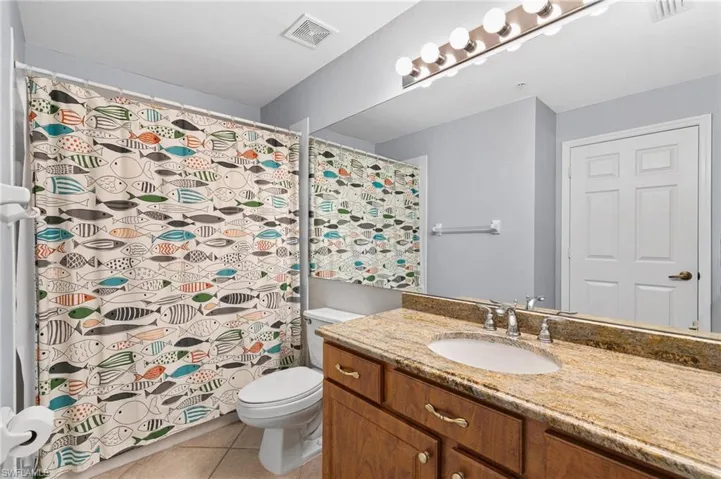 Bathroom with tile flooring, vanity, and toilet