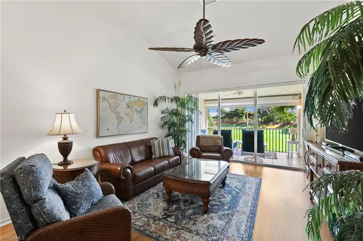 Living room featuring high vaulted ceiling, ceiling fan, and hardwood / wood-style flooring