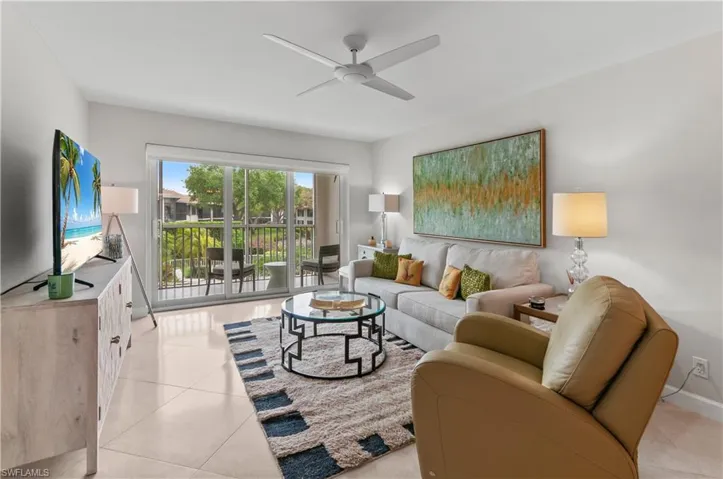Living area with a ceiling fan and light tile patterned floors