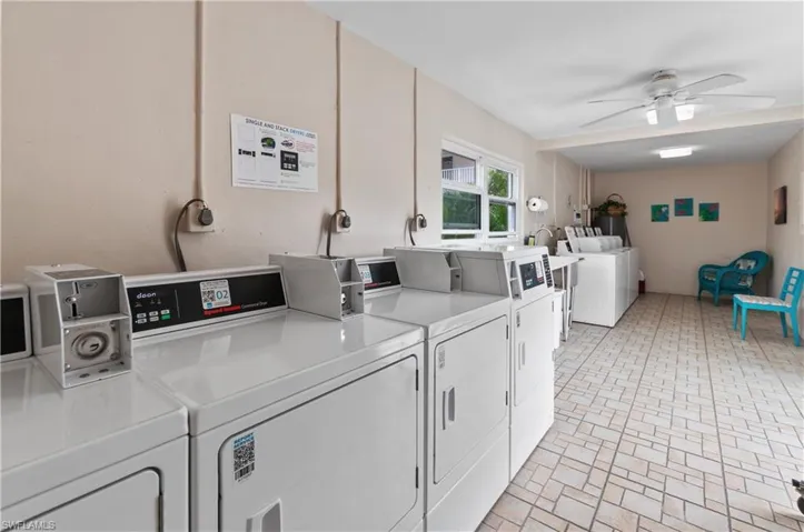 Communal laundry room featuring washing machine and clothes dryer and a ceiling fan