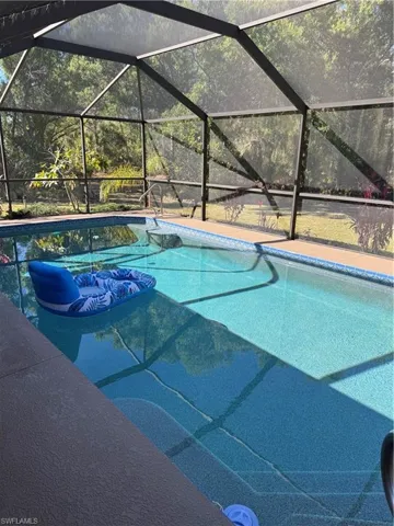 Swimming pool featuring a sunroom, a lanai, a patio area, and an outdoor living space