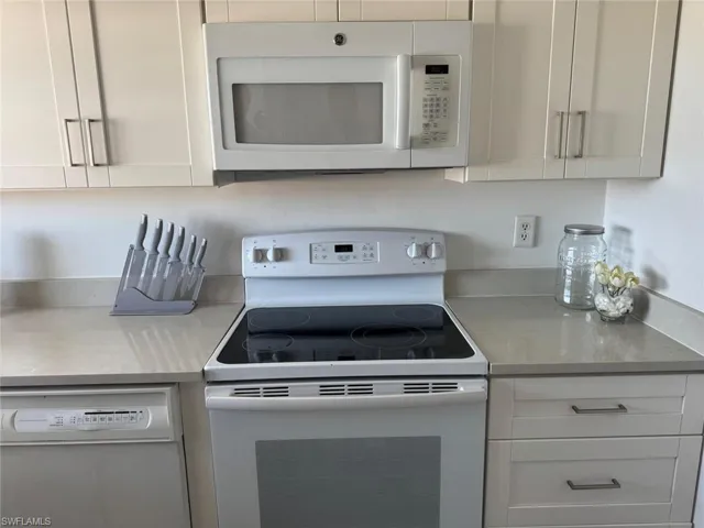 Kitchen with white appliances and white cabinets