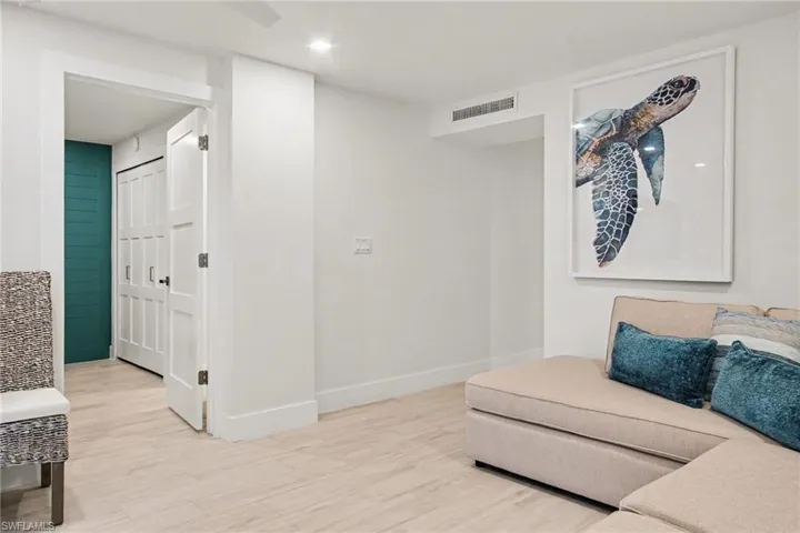 Recessed lighting illuminates the neutral-toned flooring