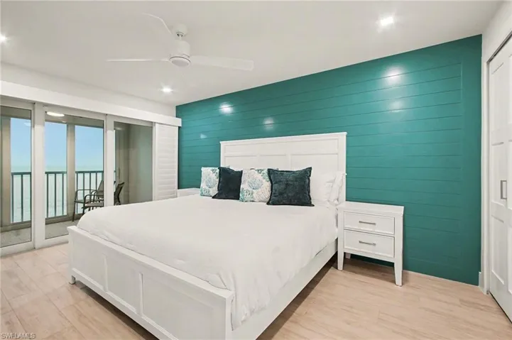 Interior space featuring a shiplap accent wall, light wood-finish flooring, and a ceiling fan with integrated lighting