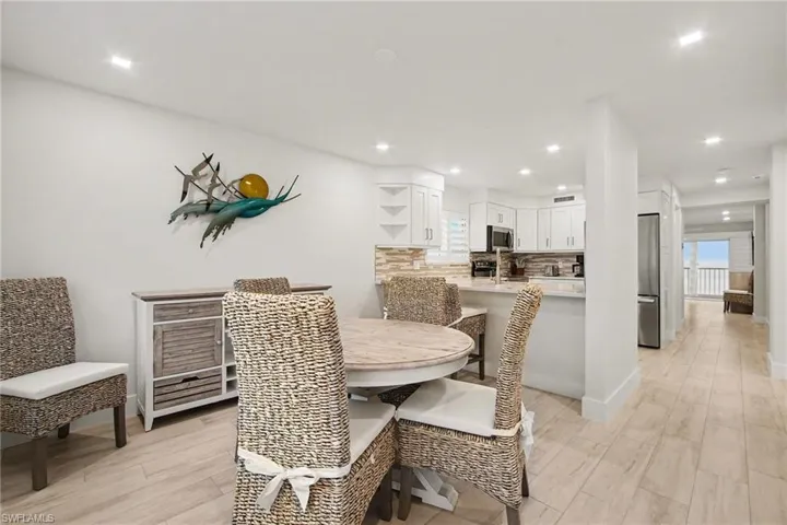 Open-concept dining area featuring light-toned wood-finish flooring