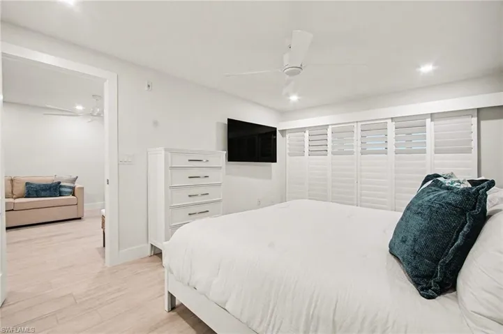 Bright room featuring a ceiling fan with integrated lighting, recessed lighting, and expansive white plantation shutters