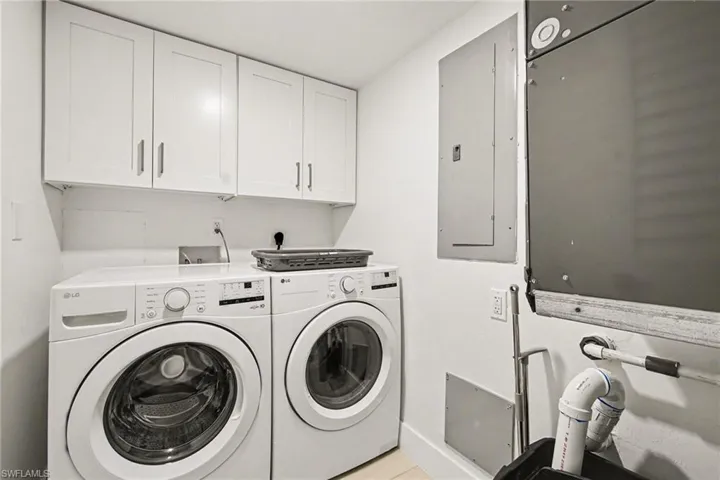 Dedicated laundry area featuring white shaker-style cabinetry, a white countertop, and light-toned flooring