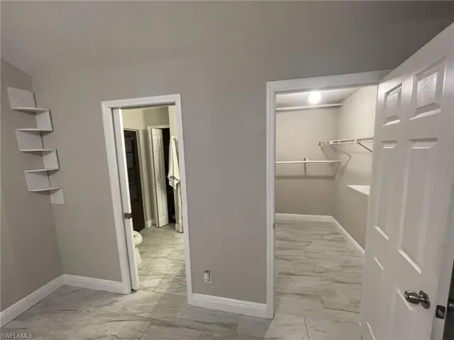 Spacious closet with light marble finish floors