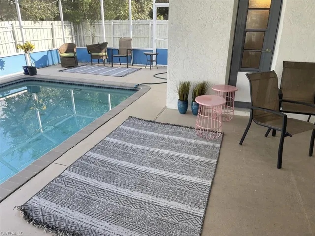 View of swimming pool with a patio area, fence, and a lanai