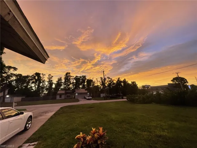 Yard at dusk featuring a yard and concrete driveway