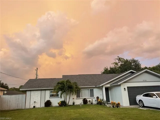Ranch-style house featuring a garage, stucco siding, and a shingled roof