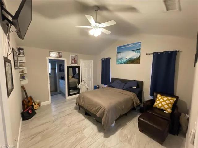 Bedroom featuring vaulted ceiling, a ceiling fan, and baseboards