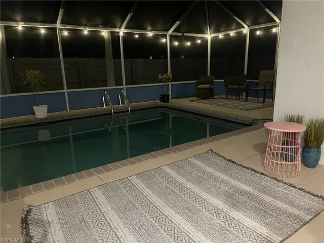Outdoor pool featuring a patio area, a lanai, and fence
