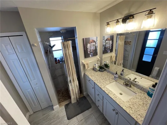 Full bathroom with a closet, vanity, a shower with curtain, and marble finish floors