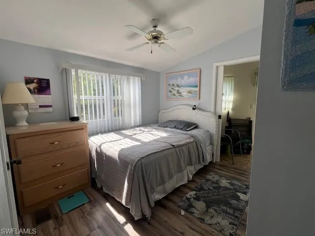Bedroom with ceiling fan, wood-type flooring, and vaulted ceiling
