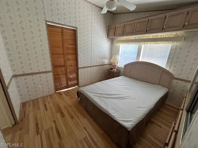 Bedroom with light hardwood / wood-style floors, a closet, and ceiling fan