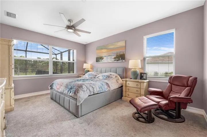 Bedroom with multiple windows, ceiling fan, and carpet
