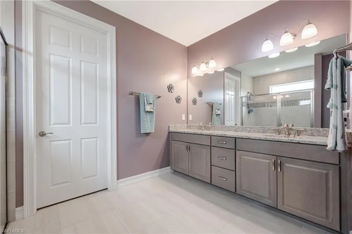 Bathroom featuring vanity and a shower with door