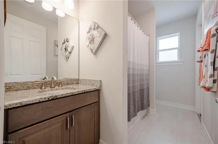 Bathroom with tile patterned flooring, vanity, and walk in shower