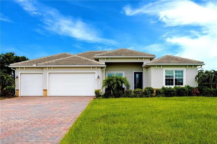 View of front of house featuring a garage and a front yard