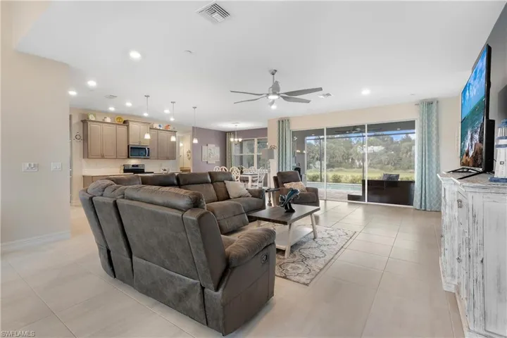 Living room with ceiling fan and light tile patterned flooring