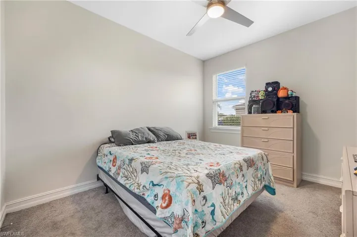 Carpeted bedroom featuring ceiling fan
