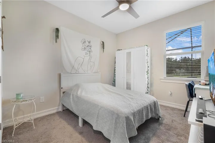 Carpeted bedroom featuring radiator and ceiling fan