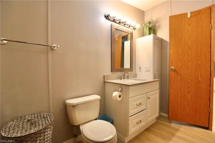 Bathroom featuring vanity, hardwood / wood-style flooring, and toilet