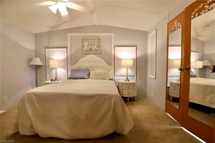 Carpeted bedroom featuring lofted ceiling and ceiling fan