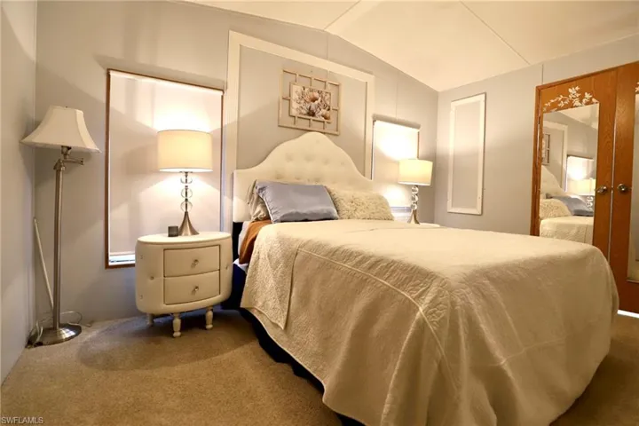 Carpeted bedroom with lofted ceiling