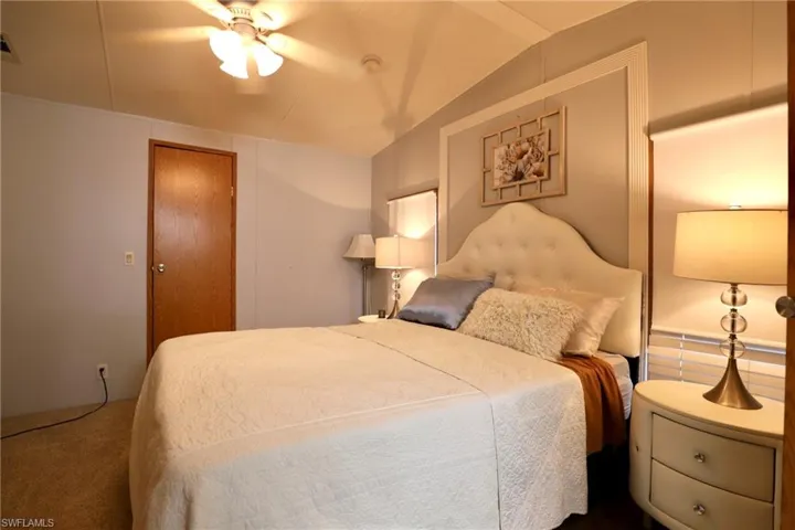 Bedroom with carpet, vaulted ceiling, and ceiling fan