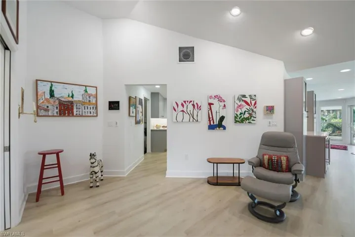 Sitting room featuring light wood-style floors, recessed lighting, and high vaulted ceiling