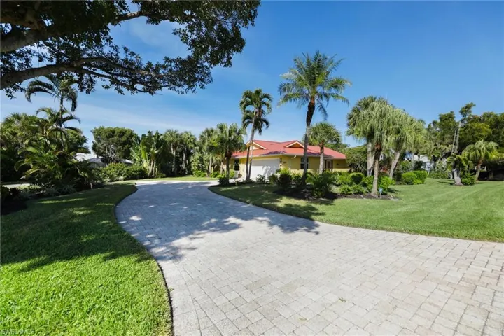 View of front of home featuring a front lawn and decorative driveway